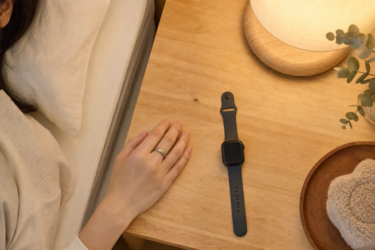指輪型と腕時計型の睡眠トラッカーを並べた寝室シーン